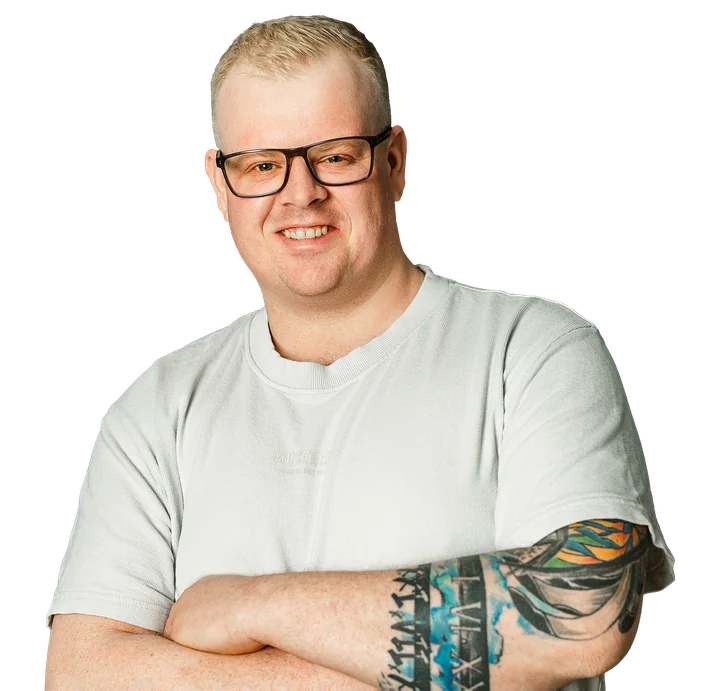 Lutz Bölling, lächelnd mit Brille und verschränkten Armen